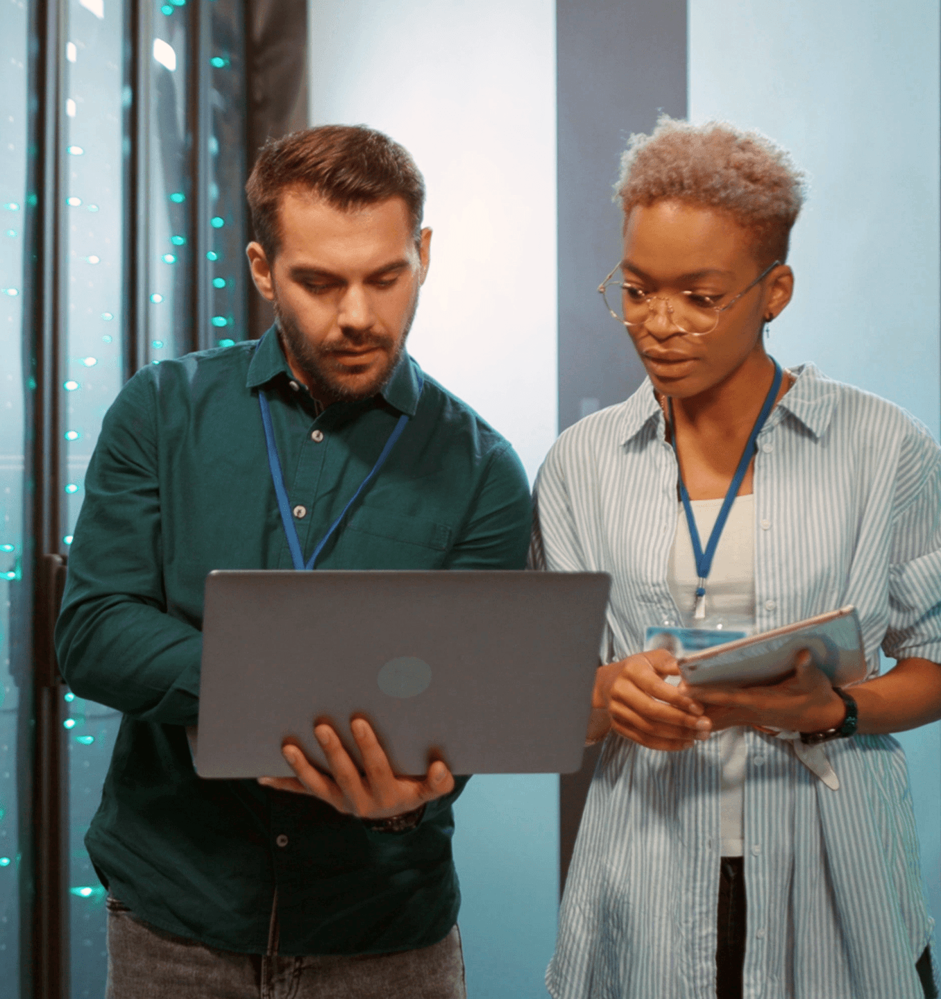 man and woman working on a laptop in a data center